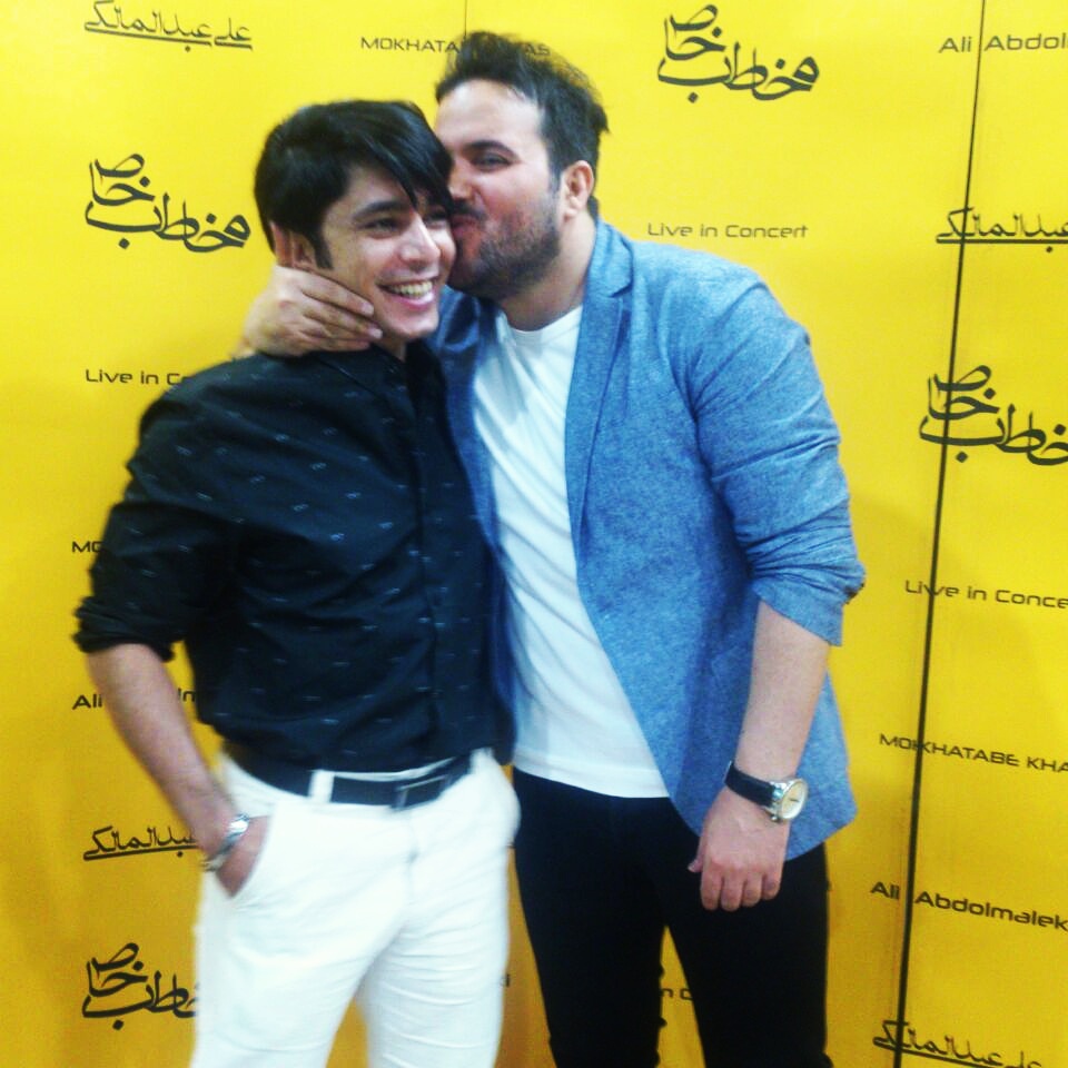 Ali Abdolmaleki kisses arash bahmani during a concert red carpet photo shooting