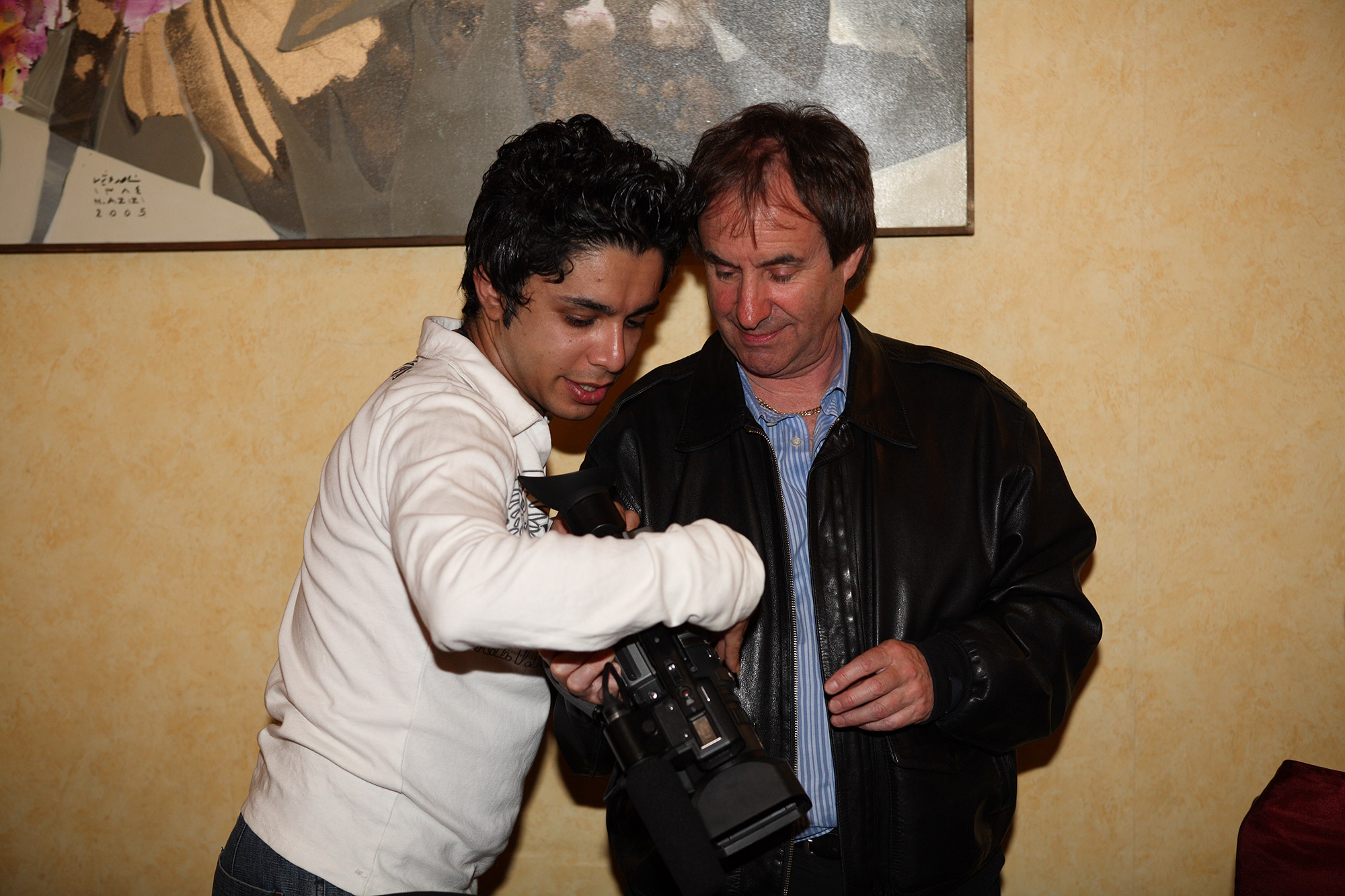 Behind the scenes of chris de burgh documentary film - arash bahmani with a white shirt teaching how to use the camera