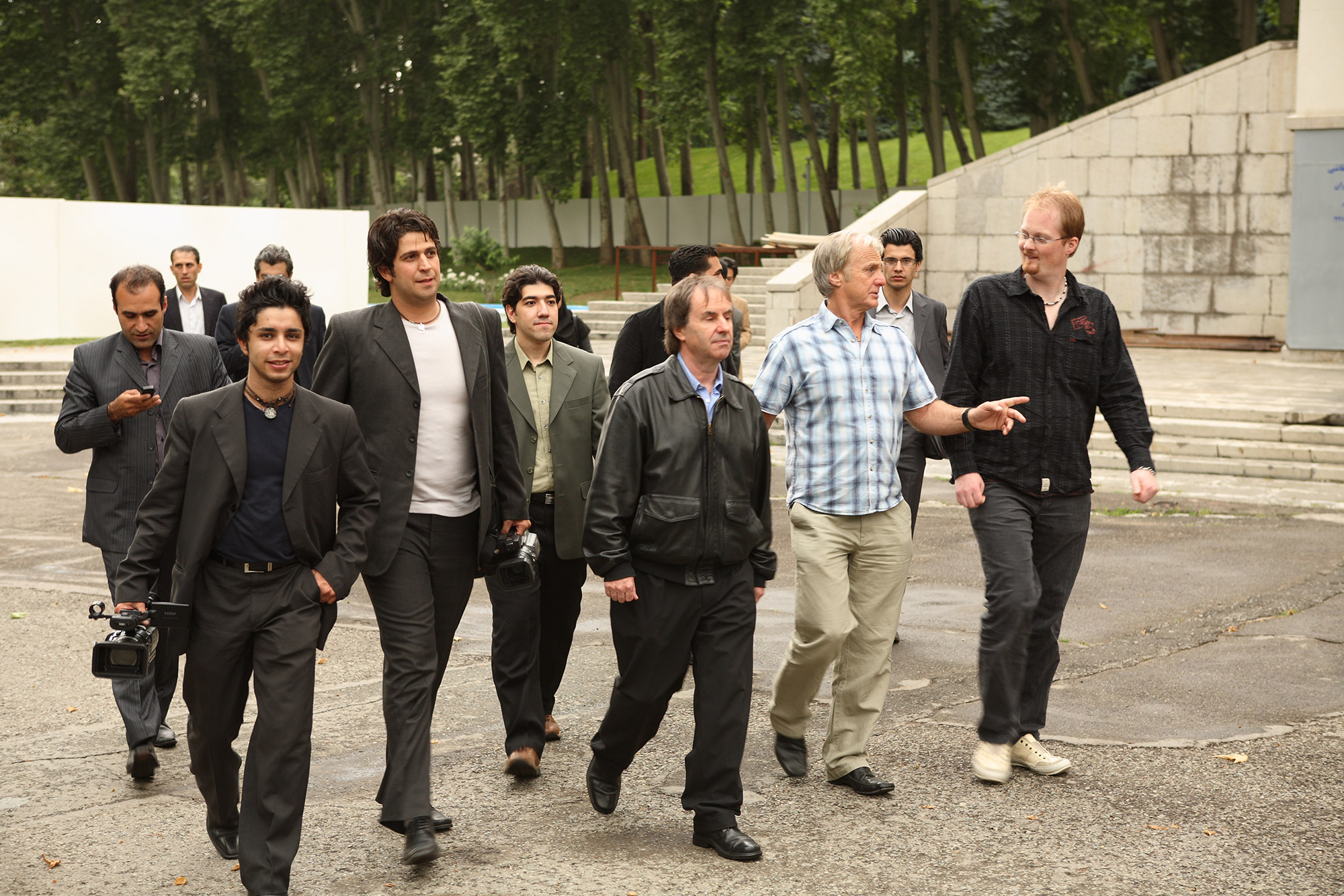 Behind the scenes of chris de burgh documentary film - arash bahmani with a camera in a gray suit