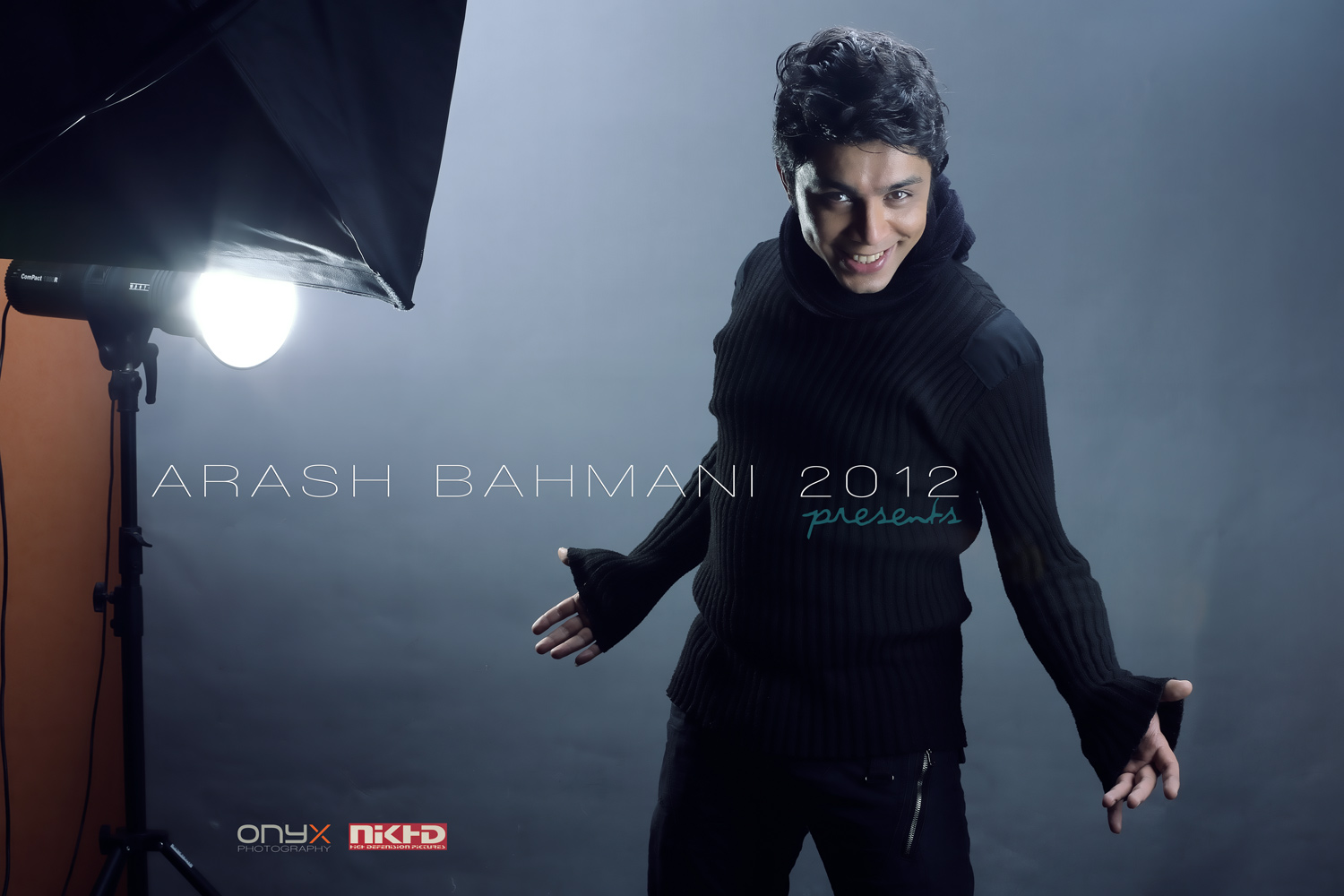 arash bahmani nik known as arash bahmani is smiling at the camera behind the scene of his music video with black clothes and lighting instruments